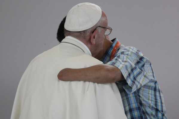 Former FARC rebel Carlos Juan Carlos Murcia, who lost his left hand, embraces Pope Francis during a prayer meeting for reconciliation at Las Malocas Park in Villavicencio, Colombia, Sept. 8, 2017. (AP Photo/Andrew Medichini, file)